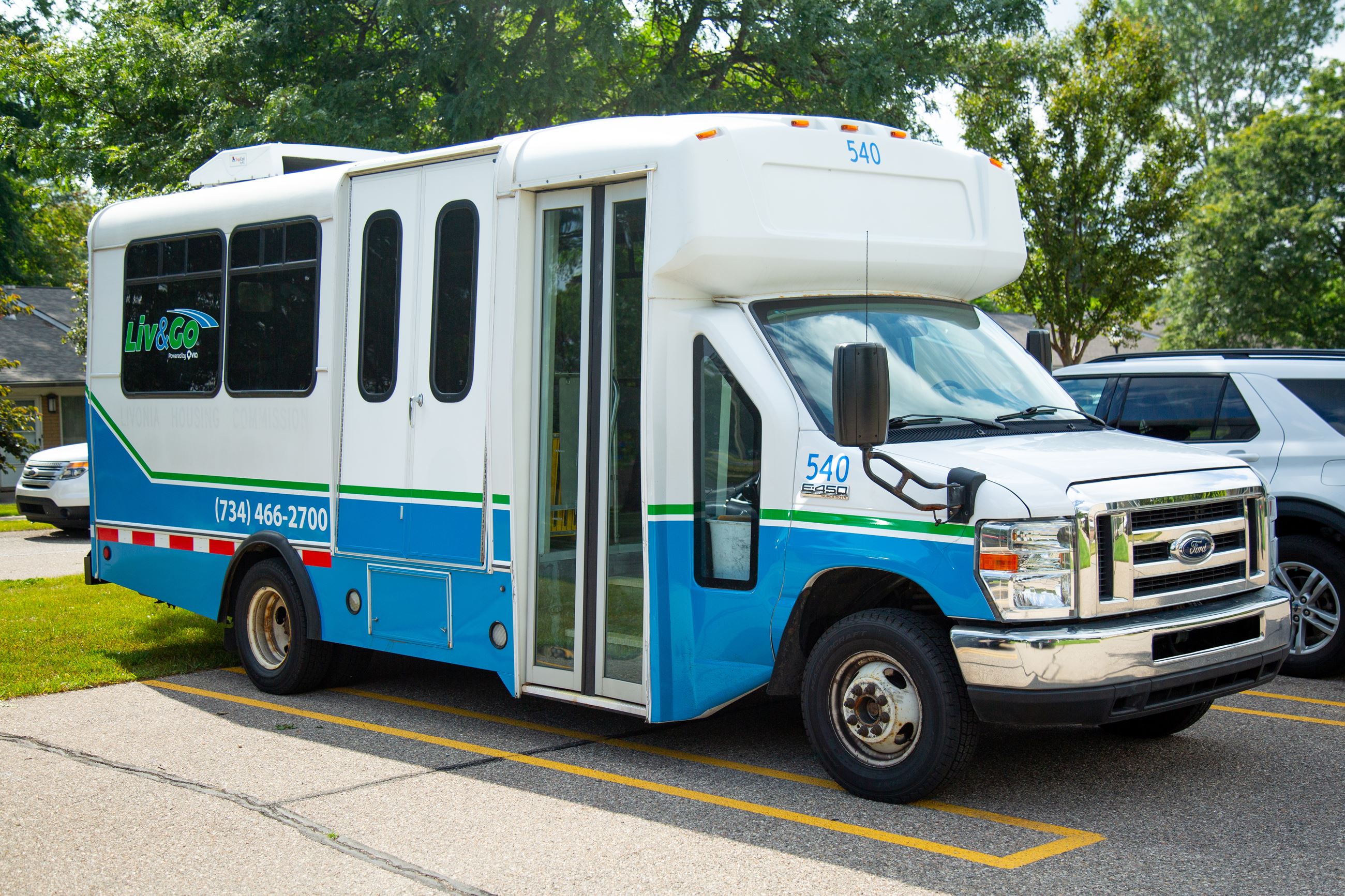 A parked bus with a Liv&Go logo wrap